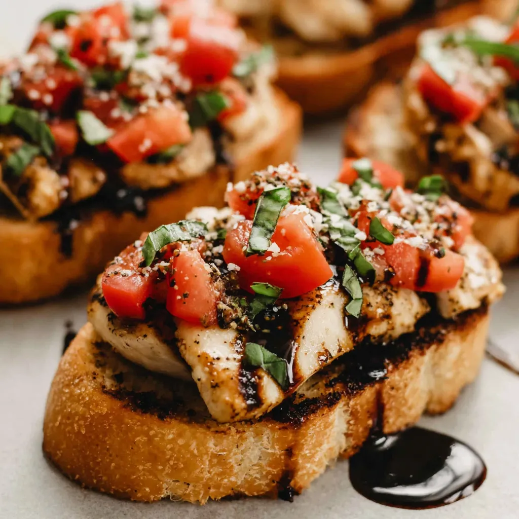 A plate of chicken bruschetta with tomatoes and basil.