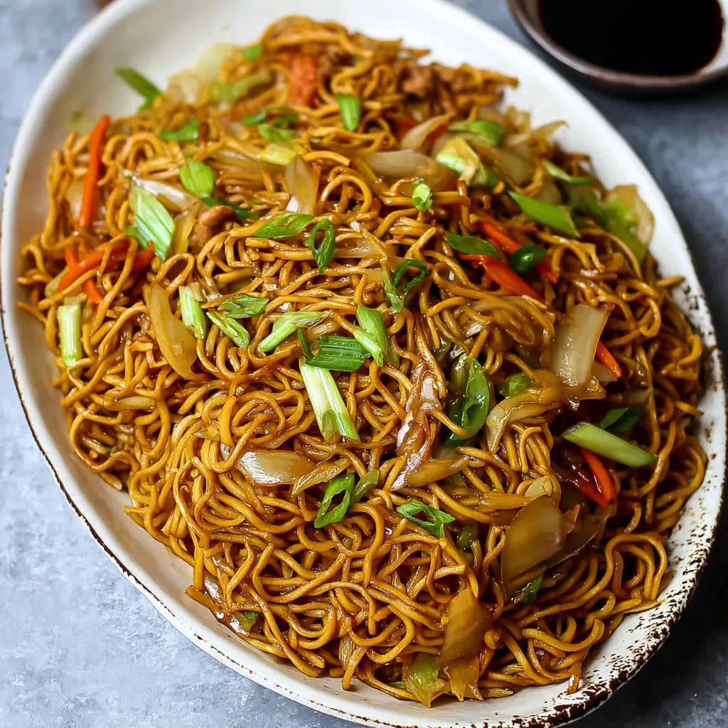 A plate of chow mein noodles with vegetables.
